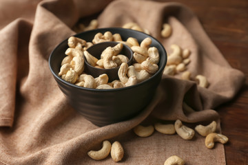 Bowl with tasty cashew nuts on table