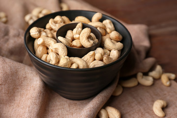 Bowl with tasty cashew nuts on table