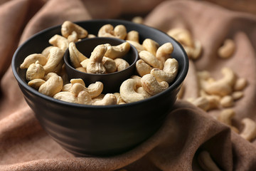 Bowl with tasty cashew nuts on table