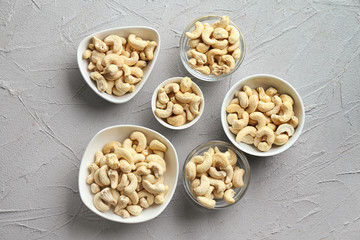 Bowls with tasty cashew nuts on light background