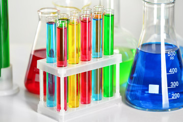 Test tubes and flask with colorful liquids on table