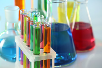 Test tubes with colorful liquids in rack, closeup