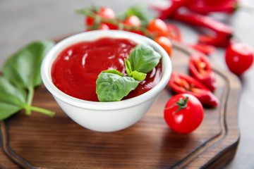 Bowl with red sauce and vegetables on table