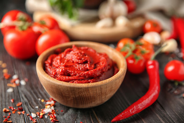 Bowl with red sauce and vegetables on table