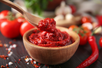 Bowl and spoon with red sauce, closeup