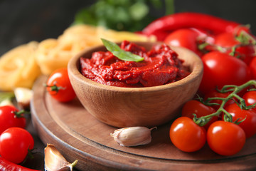 Bowl with red sauce and vegetables on table
