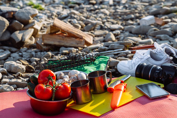 camp fire on sunset near mountain river.