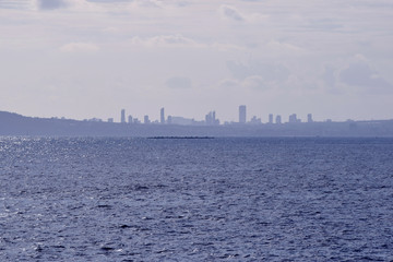 Fototapeta premium Beautiful view of the city of Calpe and the blue Spanish sky with white clouds from the promenade of the natural park of Mount Ifach