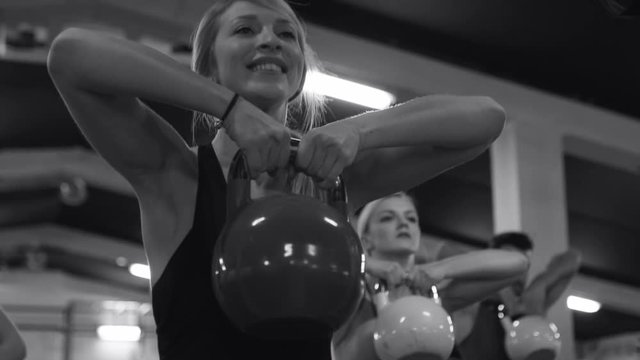 Strong muscular athletes working out training with kettlebells. .