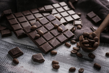 Composition with dark chocolate and coffee beans on table