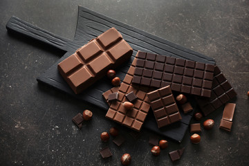 Flat lay composition with tasty chocolate and hazelnuts on gray background