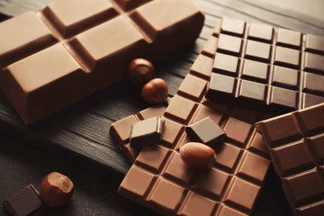 Tasty chocolate and hazelnuts on table