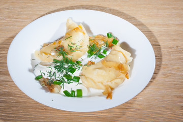 Ukrainian vareniki served on the Faror plate with onions, sour cream and dill