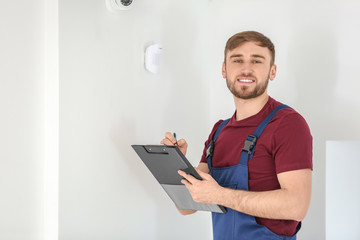 Electrician installing security camera indoors