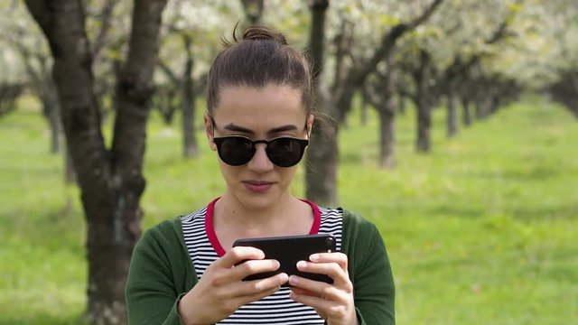Young caucasian woman with sunglasses taking photos on her phone