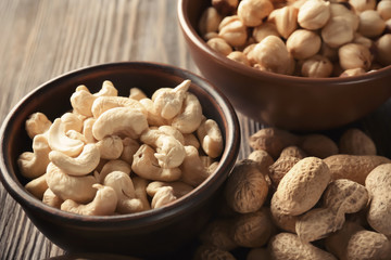 Bowls with different nuts on wooden table
