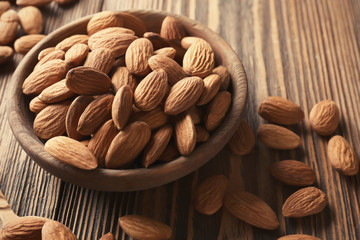 Bowl with almonds on wooden table