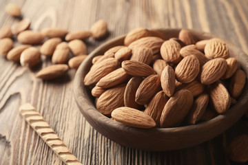 Bowl with almonds on wooden table