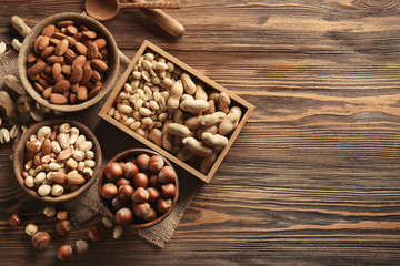 Composition with different nuts on wooden background