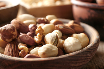Different nuts in wooden bowl, closeup