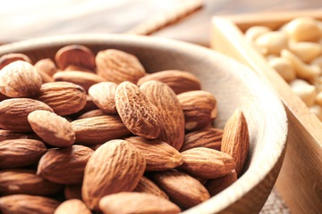 Fresh almonds in wooden bowl, closeup