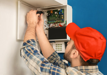 Young electrician installing alarm system