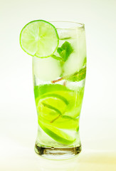 summer cold drink mojito lime and mint with ice and soda with drops on a glass on a white background