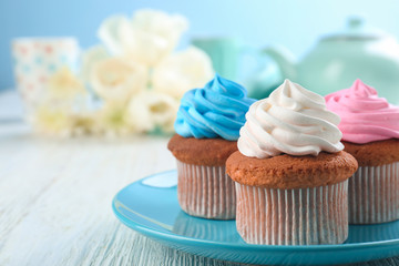 Plate with tasty cupcakes on table. Mother's Day celebration