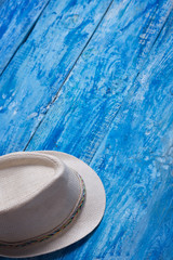Summer hat on the blue wooden background. Vertical orientation