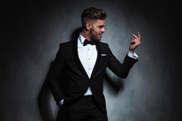 portrait of formal man looking at hand while snapping fingers