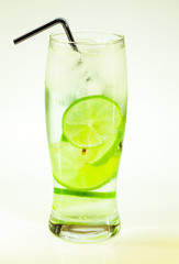 summer cold drink mojito lime and mint with ice and soda with drops on a glass on a white background