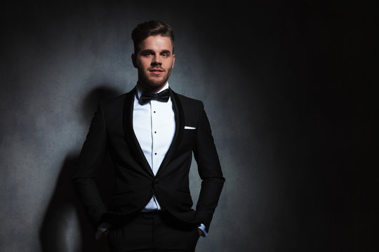 portrait of happy and relaxed young man in black tuxedo