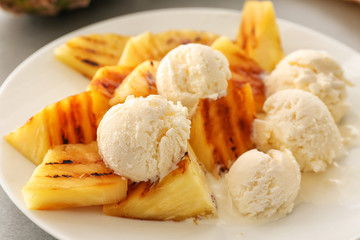 Grilled pineapple slices and ice cream on plate, closeup