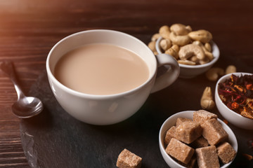 Cup of aromatic tea with milk on slate plate