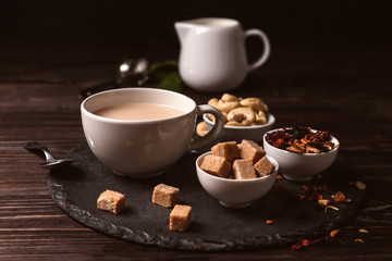 Cup of aromatic tea with milk on slate plate