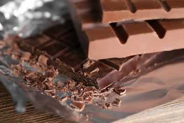 Delicious chocolate bars on foil, closeup
