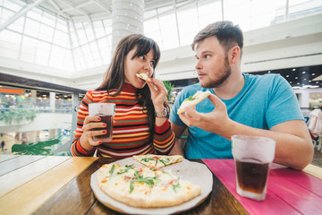 cheerful couple sitting in cafe eating pizza. hungary