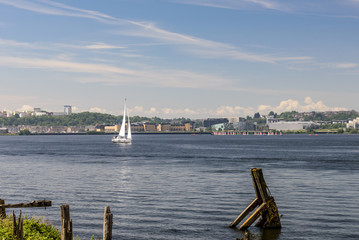 Single sail boat, sailing on Cardiff Bay, on a clear summers morning. Cardiff Bay is in South Wales.
