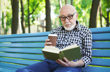 Fototapeta premium Elderly man in casual reading outdoors