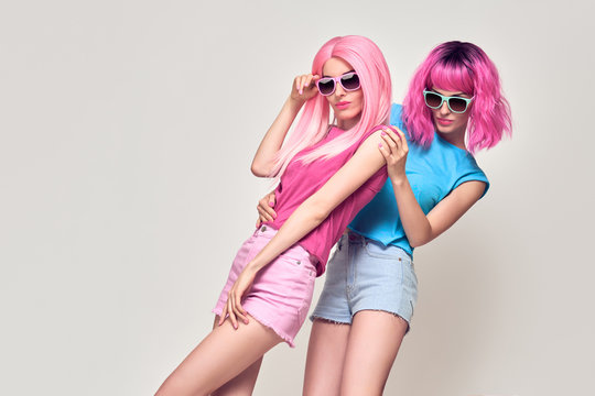 Two Girls Having Fun Dance. Pink Fashion Hairstyle