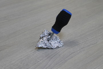 a small screwdriver stuck in aluminum foil.