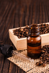 essential oil of cloves on a wooden rustic background