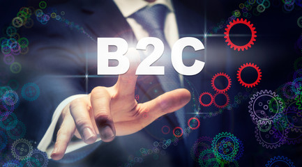 A businessman pressing a B2C business concept on a graphical display of cogs