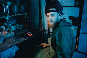 Welder man works in protective helmet, flash of light.