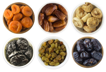 Collage of different dried fruits. Dried prunes, dried apricots, raisins, dates, figs isolated on white background. Top view. Dried fruits isolated on a white background. 