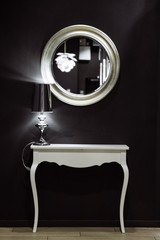 white mirror with white desk in front of black wall