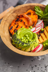 Vegan buddha bowl with tofu, spinach, avocado, rice and vegetables. Healthy vegan food concept.