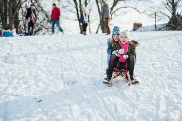 Two Girls Sledding Down the Hill