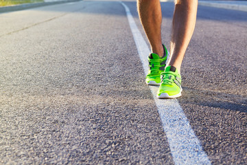 Runner man feet running on road closeup on shoe. Male fitness athlete jogger workout in wellness...
