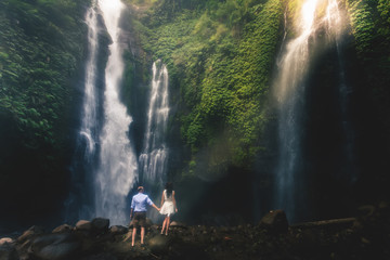 Amazing romantic view of happy couple near beautiful grand waterfall